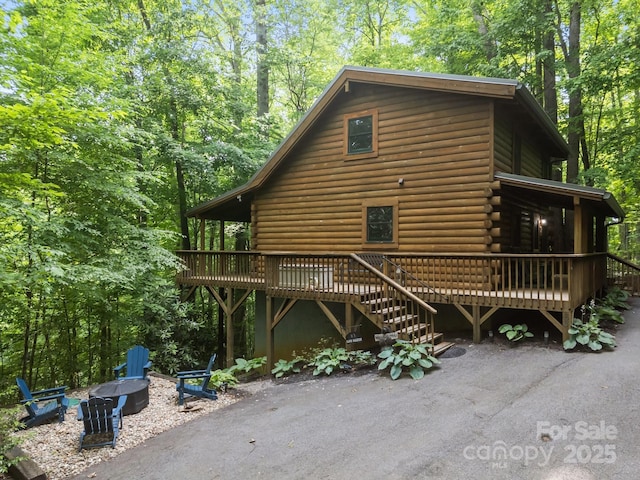 83 Log Cabin Dr, Maggie Valley, NC 28751 - view of home's exterior with a deck, an outdoor fire pit, log siding, stairway, and a patio area