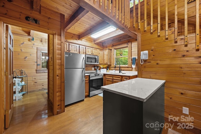 83 Log Cabin Dr, Maggie Valley, NC 28751 - kitchen with appliances with stainless steel finishes, wooden walls, light wood-style floors, a wooden ceiling with exposed beams, and light stone countertops