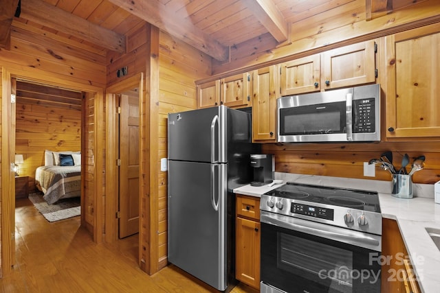 83 Log Cabin Dr, Maggie Valley, NC 28751 - kitchen featuring appliances with stainless steel finishes, a wooden ceiling with exposed beams, light countertops, light wood-style floors, and wood walls