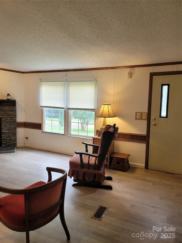 111 Crystal Creek Dr, China Grove, NC 28023 - sitting room featuring a textured ceiling, wood finished floors, crown molding, and wainscoting