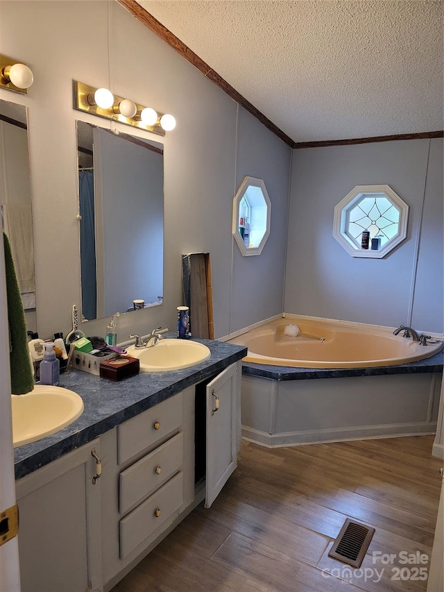 111 Crystal Creek Dr, China Grove, NC 28023 - bathroom with a textured ceiling, double vanity, wood finished floors, a garden tub, and crown molding