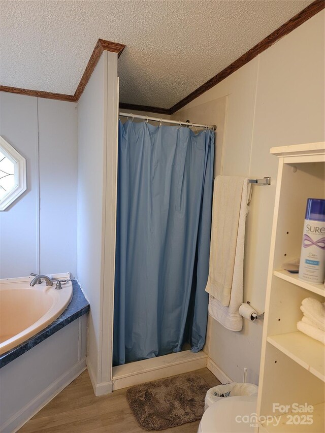 111 Crystal Creek Dr, China Grove, NC 28023 - bathroom with crown molding, a textured ceiling, a stall shower, wood finished floors, and a garden tub