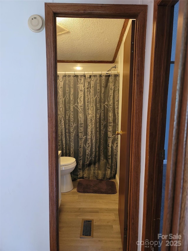 111 Crystal Creek Dr, China Grove, NC 28023 - full bath with wood finished floors, a textured ceiling, ornamental molding, and a shower with shower curtain