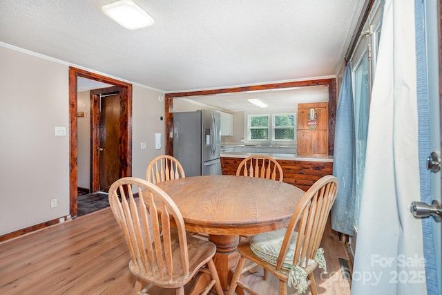 439 Neisler Rd, Concord, NC 28025 - dining area with light wood-style floors, a textured ceiling, and crown molding
