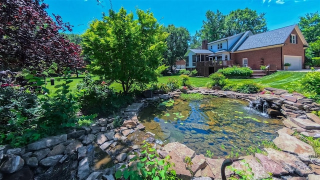 1240 Fawn Ridge Rd NW, Concord, NC 28027 - view of grassy yard featuring a garden pond, a garage, and a wooden deck