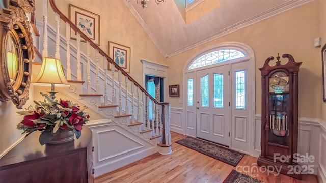1240 Fawn Ridge Rd NW, Concord, NC 28027 - entrance foyer featuring light wood finished floors, a high ceiling, a decorative wall, stairs, and crown molding