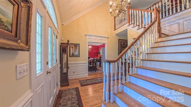 1240 Fawn Ridge Rd NW, Concord, NC 28027 - foyer entrance featuring crown molding, stairway, wood finished floors, wainscoting, and a chandelier