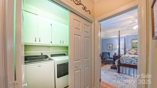 1240 Fawn Ridge Rd NW, Concord, NC 28027 - washroom with cabinet space, washing machine and dryer, light wood-type flooring, and ornamental molding