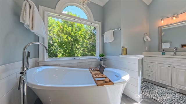 1240 Fawn Ridge Rd NW, Concord, NC 28027 - bathroom featuring a freestanding bath, vanity, tile walls, and wainscoting