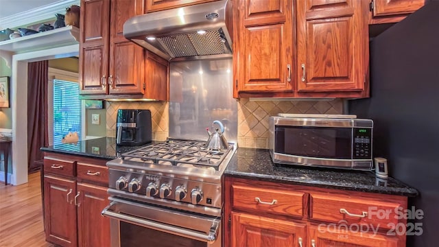 1240 Fawn Ridge Rd NW, Concord, NC 28027 - kitchen with exhaust hood, appliances with stainless steel finishes, dark stone countertops, light wood finished floors, and tasteful backsplash