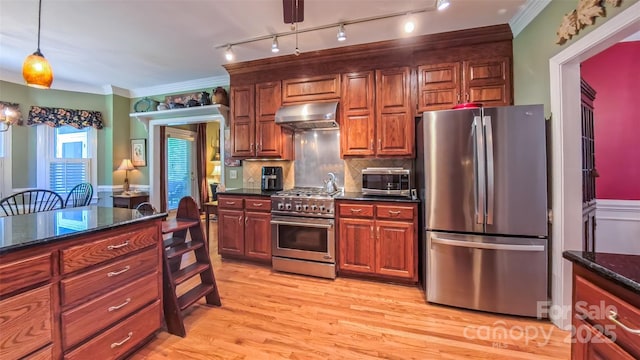 1240 Fawn Ridge Rd NW, Concord, NC 28027 - kitchen with appliances with stainless steel finishes, under cabinet range hood, decorative light fixtures, light wood-type flooring, and tasteful backsplash
