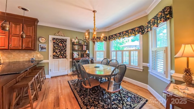 1240 Fawn Ridge Rd NW, Concord, NC 28027 - dining room featuring a chandelier, healthy amount of natural light, light wood-type flooring, and ornamental molding