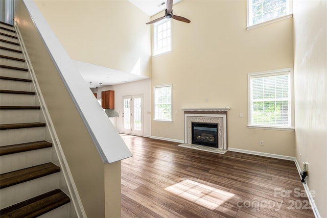 89 Woodfern Rd, Fletcher, NC 28732 - unfurnished living room featuring a towering ceiling, stairway, ceiling fan, healthy amount of natural light, and wood finished floors