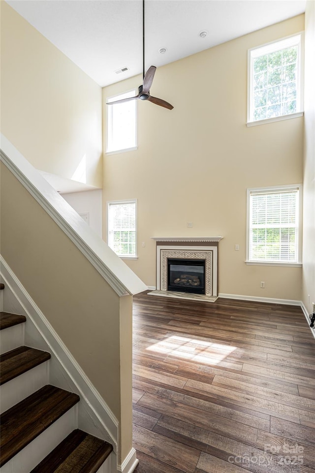 89 Woodfern Rd, Fletcher, NC 28732 - unfurnished living room with a high ceiling, ceiling fan, stairway, wood-type flooring, and a fireplace with flush hearth