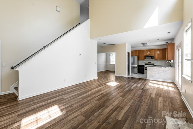 89 Woodfern Rd, Fletcher, NC 28732 - unfurnished living room with dark wood-type flooring, a towering ceiling, and stairs