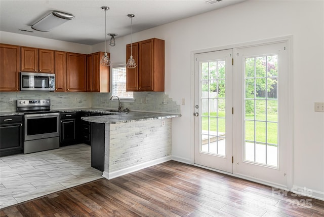 89 Woodfern Rd, Fletcher, NC 28732 - kitchen featuring appliances with stainless steel finishes, brown cabinets, decorative backsplash, and a peninsula