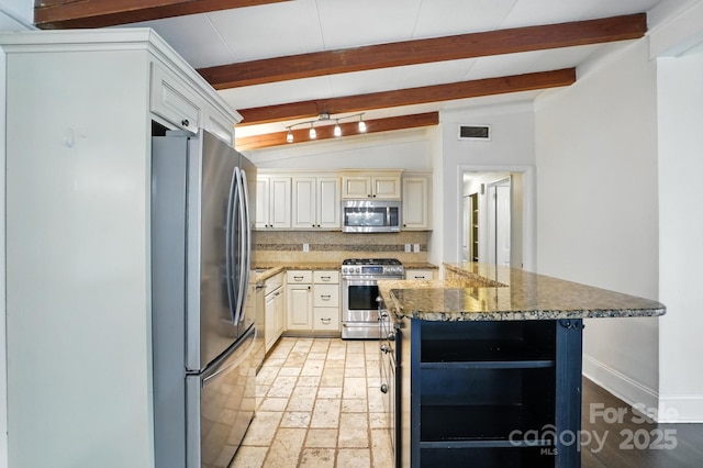 5229 Milford Rd, Charlotte, NC 28210 - kitchen with appliances with stainless steel finishes, decorative backsplash, cream cabinetry, dark stone counters, and open shelves