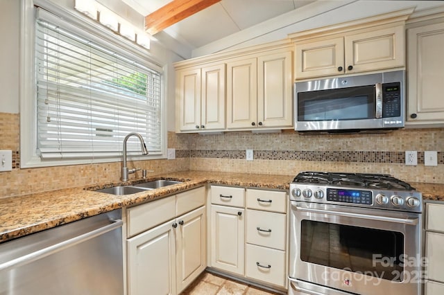 5229 Milford Rd, Charlotte, NC 28210 - kitchen featuring appliances with stainless steel finishes, cream cabinetry, decorative backsplash, and light stone countertops