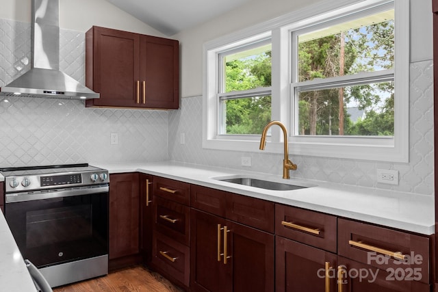 1115 Sides Rd, Salisbury, NC 28146 - kitchen featuring wall chimney range hood, stainless steel range with electric stovetop, lofted ceiling, light countertops, and light wood-type flooring