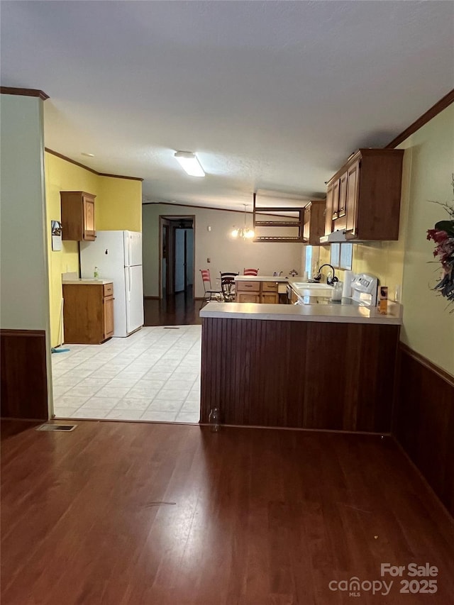 184 Winding Arbor Cir, Cleveland, NC 27013 - kitchen featuring a peninsula, light wood-style floors, freestanding refrigerator, light countertops, and range