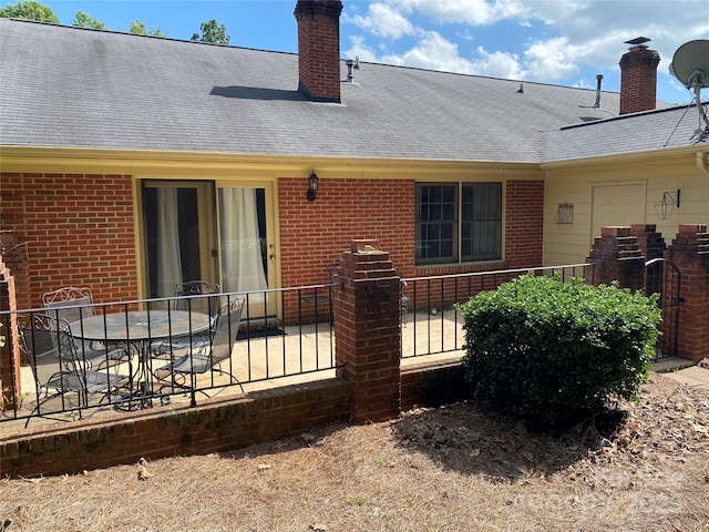 8421 Coulwood Oak Ln, Charlotte, NC 28214 - rear view of house with brick siding, a chimney, a patio, and a shingled roof