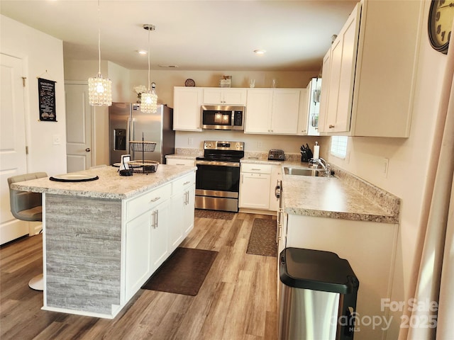 1047 Campbell Chase Ln SW, Concord, NC 28025 - kitchen featuring appliances with stainless steel finishes, a center island, light wood-style flooring, recessed lighting, and white cabinetry