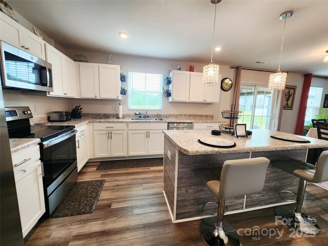 1047 Campbell Chase Ln SW, Concord, NC 28025 - kitchen with stainless steel appliances, a breakfast bar, healthy amount of natural light, white cabinets, and recessed lighting