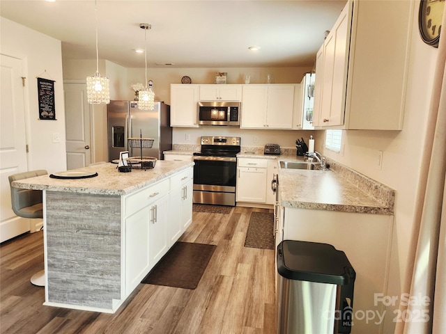 1047 Campbell Chase Ln SW, Concord, NC 28025 - kitchen with appliances with stainless steel finishes, light wood-type flooring, a kitchen island, white cabinetry, and recessed lighting