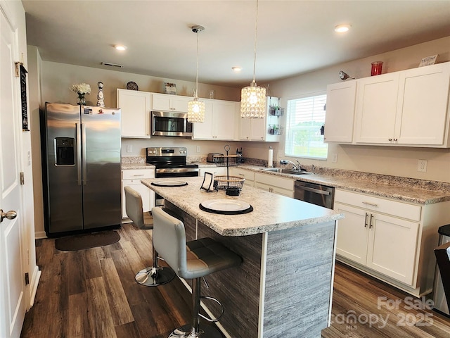 1047 Campbell Chase Ln SW, Concord, NC 28025 - kitchen with stainless steel appliances, white cabinets, pendant lighting, recessed lighting, and a kitchen bar