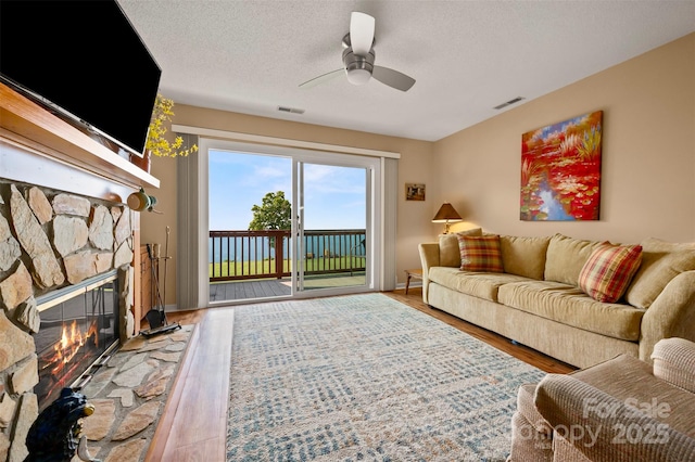 2881 White Oak Mountain Rd Unit D5, Columbus, NC 28722 - living room with wood finished floors, a fireplace, ceiling fan, and a textured ceiling