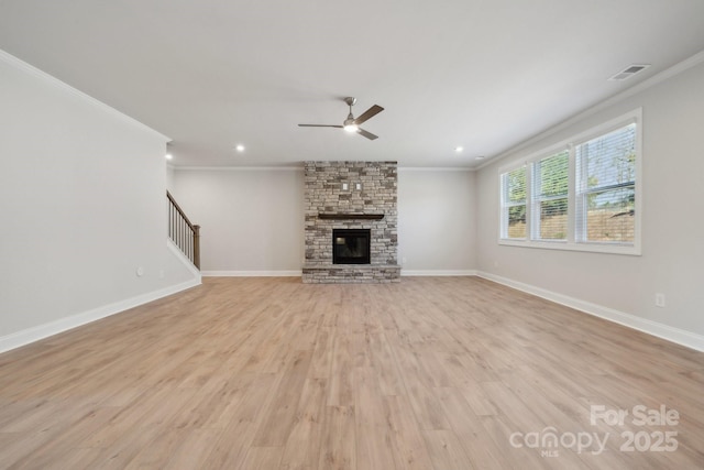 308 Alameda Way, Matthews, NC 28104 - unfurnished living room featuring ornamental molding, a ceiling fan, light wood-type flooring, a fireplace, and stairs