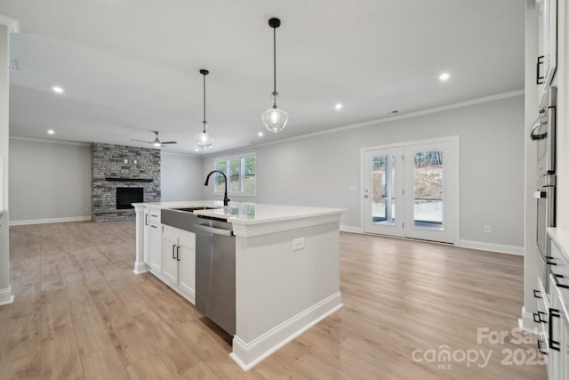 308 Alameda Way, Matthews, NC 28104 - kitchen featuring open floor plan, stainless steel dishwasher, crown molding, a ceiling fan, and a fireplace