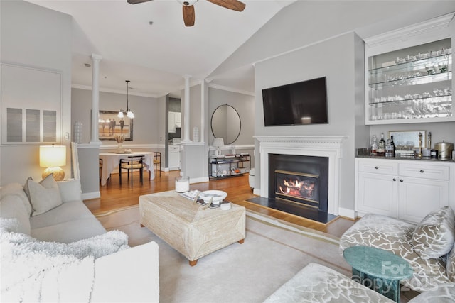 5730 Closeburn Rd Unit N, Charlotte, NC 28210 - living room featuring light wood-style flooring, ornate columns, ceiling fan, ornamental molding, and a glass covered fireplace
