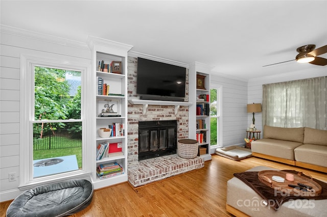8300 Quarters Ln, Mint Hill, NC 28227 - living room with wood finished floors, crown molding, a fireplace, ceiling fan, and wood walls