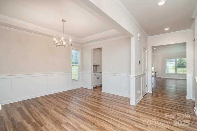 8420 Golden Stone Ln Unit 138, Fort Mill, SC 29707 - unfurnished dining area featuring light wood-type flooring, a chandelier, crown molding, and a wainscoted wall
