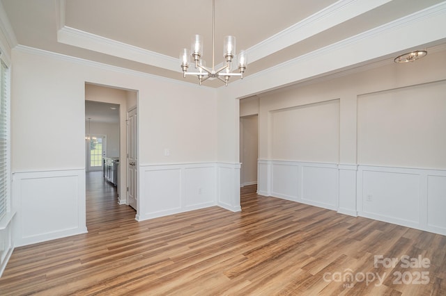 8420 Golden Stone Ln Unit 138, Fort Mill, SC 29707 - unfurnished dining area with a chandelier, ornamental molding, a decorative wall, light wood-style floors, and a raised ceiling
