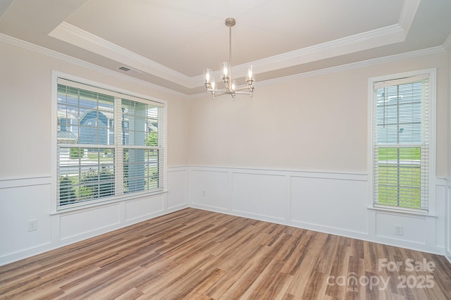 8420 Golden Stone Ln Unit 138, Fort Mill, SC 29707 - unfurnished room featuring a tray ceiling, a chandelier, wood finished floors, ornamental molding, and a decorative wall