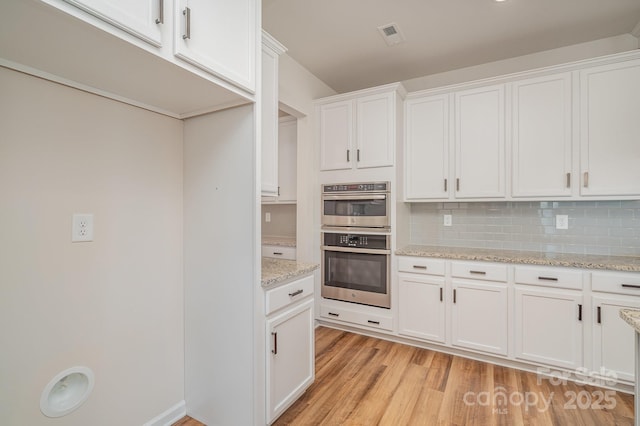 8420 Golden Stone Ln Unit 138, Fort Mill, SC 29707 - kitchen featuring stainless steel double oven, light wood-style flooring, white cabinets, and backsplash