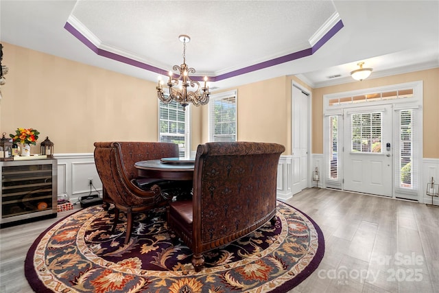 1152 Mckee Farm Ln, Belmont, NC 28012 - dining room featuring wine cooler, a tray ceiling, a decorative wall, a chandelier, and ornamental molding