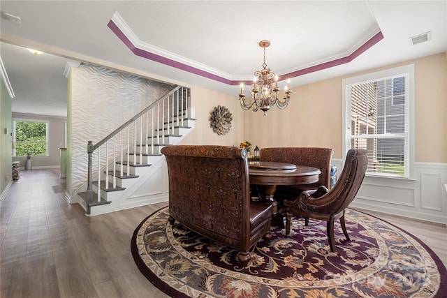 1152 Mckee Farm Ln, Belmont, NC 28012 - dining area featuring stairway, wood finished floors, a chandelier, a raised ceiling, and crown molding
