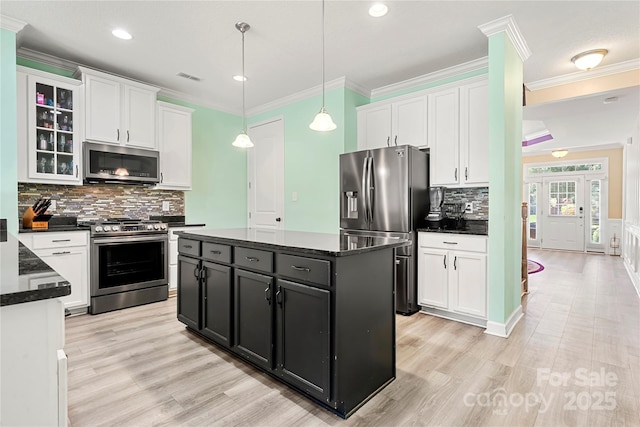 1152 Mckee Farm Ln, Belmont, NC 28012 - kitchen with appliances with stainless steel finishes, white cabinetry, dark cabinetry, light wood-style flooring, and ornamental molding
