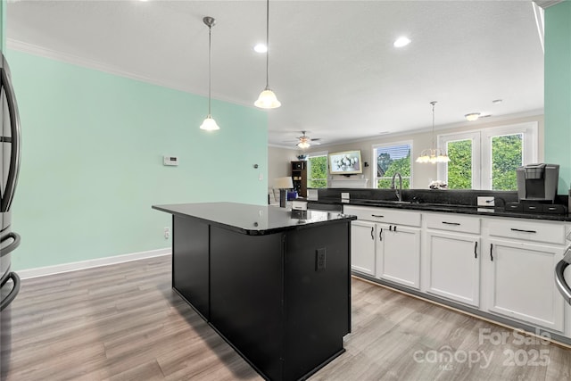 1152 Mckee Farm Ln, Belmont, NC 28012 - kitchen featuring ornamental molding, light wood-style floors, white cabinetry, a center island, and pendant lighting