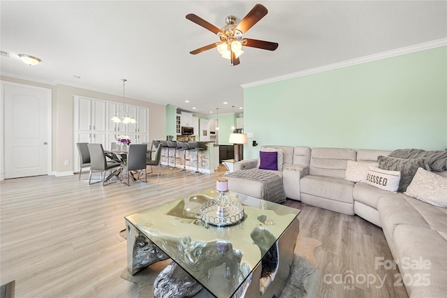 1152 Mckee Farm Ln, Belmont, NC 28012 - living room featuring ornamental molding, light wood-style floors, a ceiling fan, and a chandelier