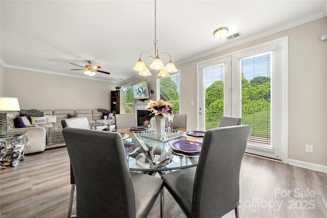 1152 Mckee Farm Ln, Belmont, NC 28012 - dining space with crown molding, light wood-type flooring, a chandelier, and ceiling fan