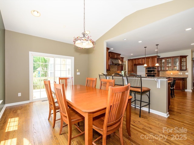 9212 John Hawks Rd, Cornelius, NC 28031 - dining room featuring light wood-style floors, vaulted ceiling, recessed lighting, and a chandelier