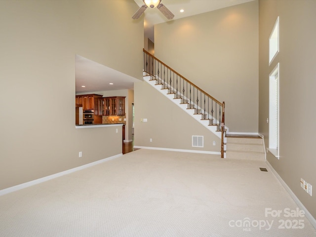 9212 John Hawks Rd, Cornelius, NC 28031 - unfurnished living room featuring stairway, a towering ceiling, light colored carpet, ceiling fan, and recessed lighting