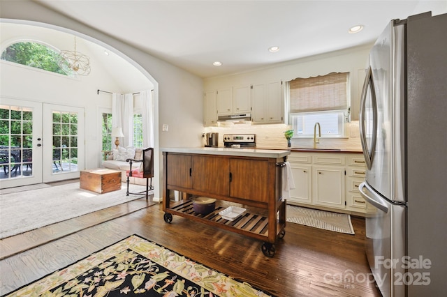 1040 Goshen Pl, Charlotte, NC 28211 - kitchen featuring freestanding refrigerator, wood finished floors, decorative backsplash, range with electric stovetop, and arched walkways