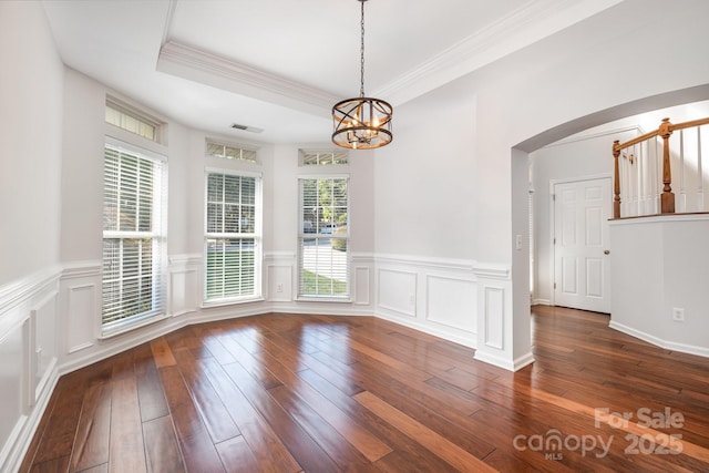 19509 Trintella Ln, Cornelius, NC 28031 - unfurnished dining area featuring arched walkways, a chandelier, hardwood / wood-style floors, crown molding, and wainscoting