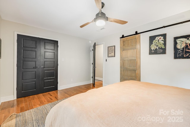 90 Reed Rd, Asheville, NC 28805 - bedroom featuring a barn door, wood finished floors, and a ceiling fan