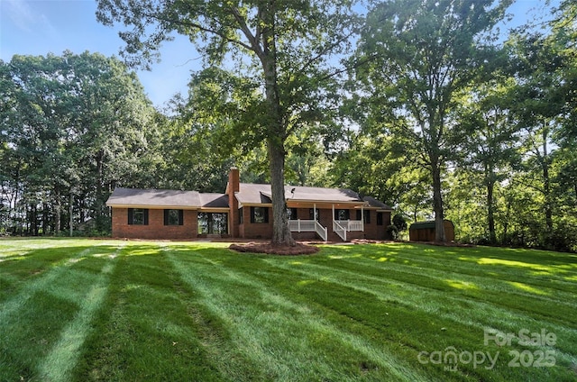 4323 Crow Rd, Monroe, NC 28112 - back of property featuring a storage unit, a lawn, covered porch, and a chimney